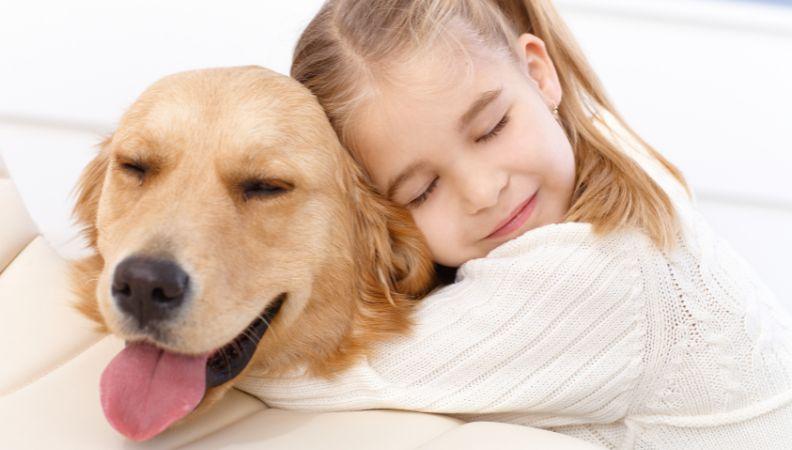 Little girl hugging a dog looking after pets