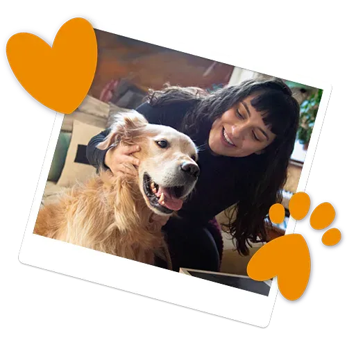 A smiling woman cuddling her Golden Retriever dog