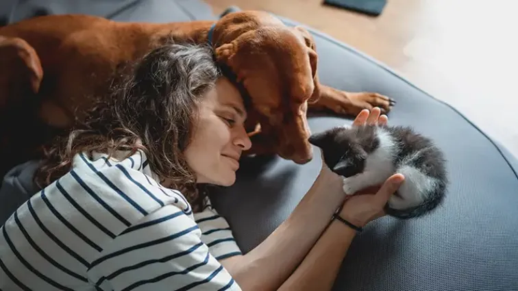 An owner with her dog and kitten